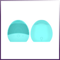 Front and back view of a light blue silicone facial cleansing brush.