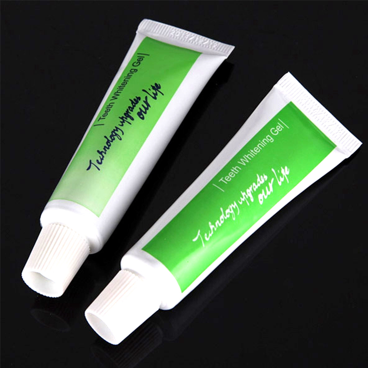 Two tubes of Teeth Whitening Gel with green and white packaging on a dark background.