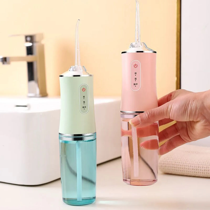 Cordless water flosser held in hand at bathroom sink